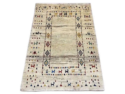 Gabbeh rug with a beige background, rectangular medallion, and colorful decorative stripes