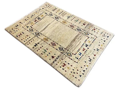 Gabbeh rug with a beige background, graphic border and medallion, diagonal view