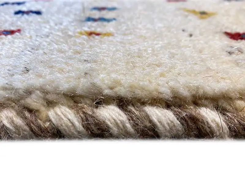 Gabbeh rug close-up of the pile edge with multicolored embroidered trim