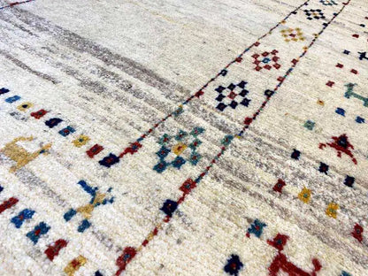 Gabbeh rug detail: geometric ornaments in blue, red, and black on a light background