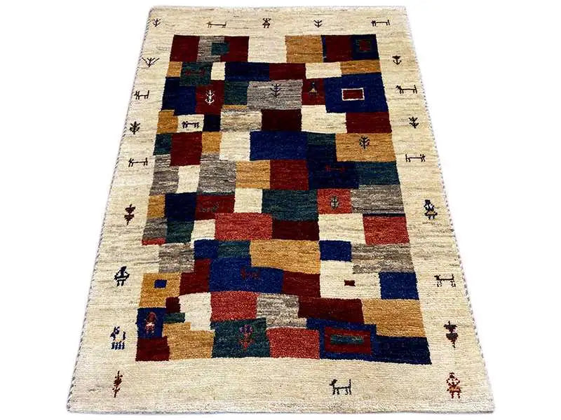 Gabbeh rug with a geometric patchwork pattern, beige background, and shades of blue, red, and green.