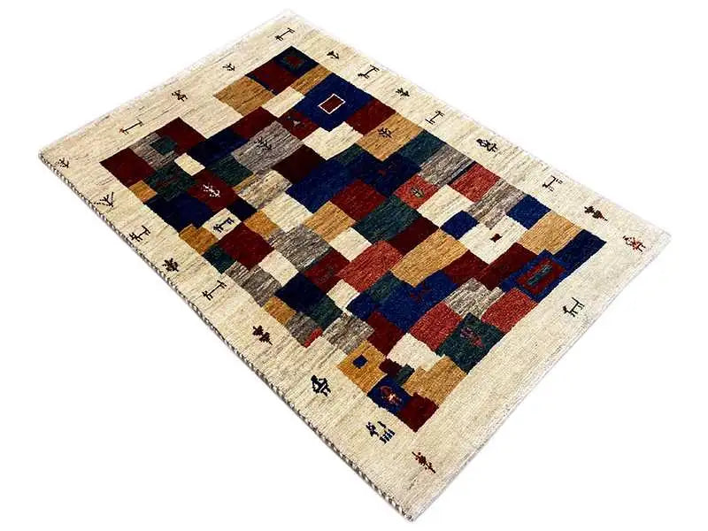Gabbeh rug with square patchwork in shades of red, blue, beige, and gray.