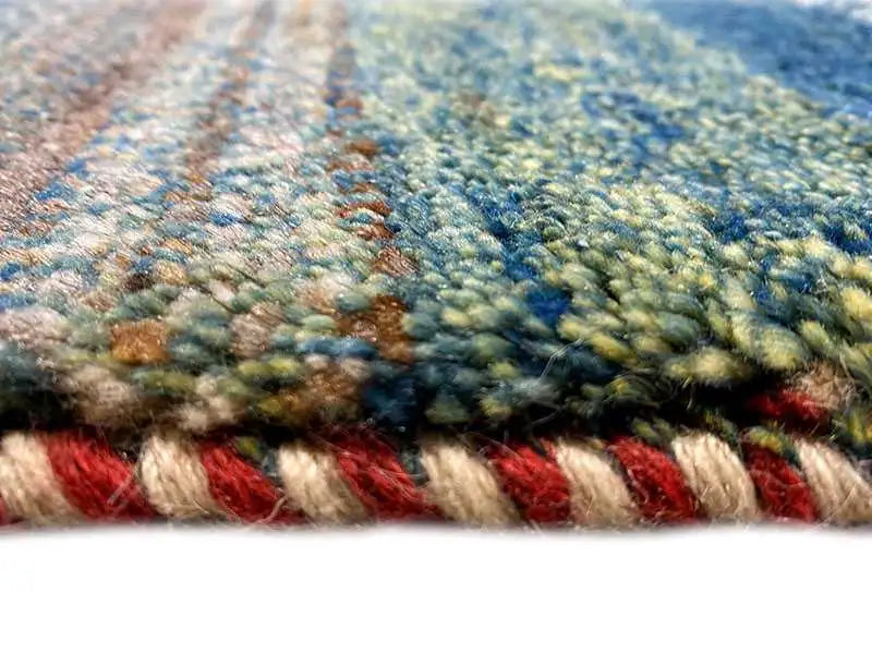 Gabbeh rug detail: dense pile with red and blue accents along the edge