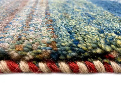 Gabbeh rug detail: dense pile with red and blue accents along the edge