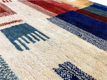 Gabbeh rug close-up with stripes and symbolic motifs in blue, red, and beige
