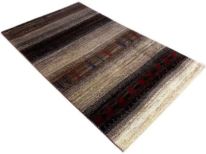 Gabbeh rug, shown at an angle; dark brown stripes with beige, red, and blue motifs