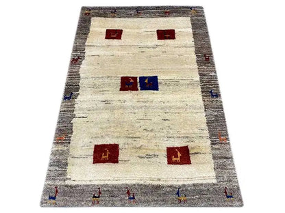 Gabbeh rug, rectangular, with a light beige color, gray border, and red/blue squares