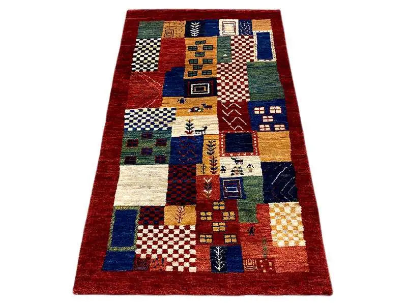 Gabbeh rug with a patchwork pattern in red, blue, beige and green, rectangular
