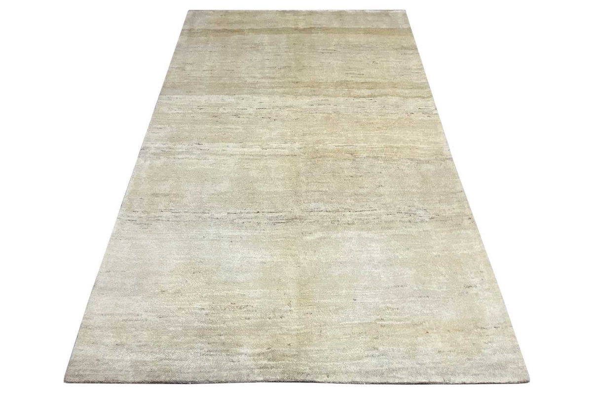Gabbeh rug with a light beige, uniform woven pattern, greatly spread out
