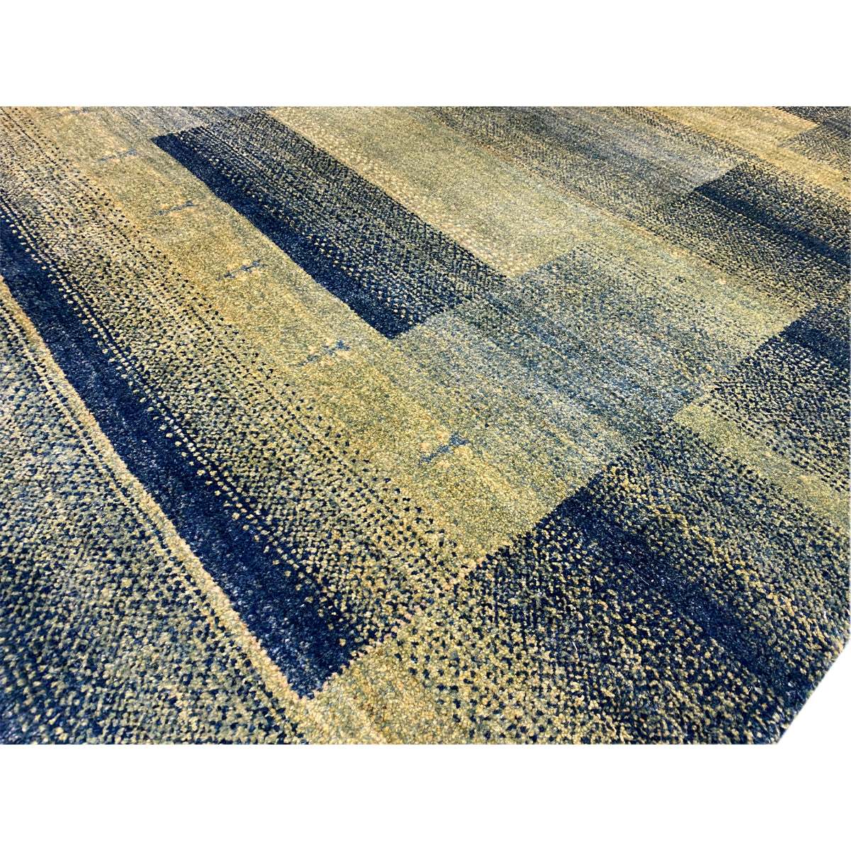 Gabbeh rug green close-up: mottled woven pattern with rectangular sections.