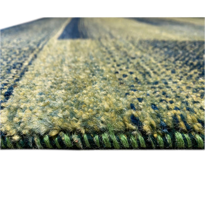 Green gabbeh rug, close-up of the pile surface, mottled texture, with edge.