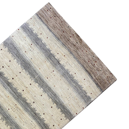 Gabbeh rug at an angle: light beige stripes with gray-brown contrasts