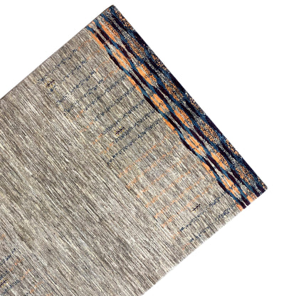 Gray Gabbeh rug, draped diagonally, with blue-orange border stripes