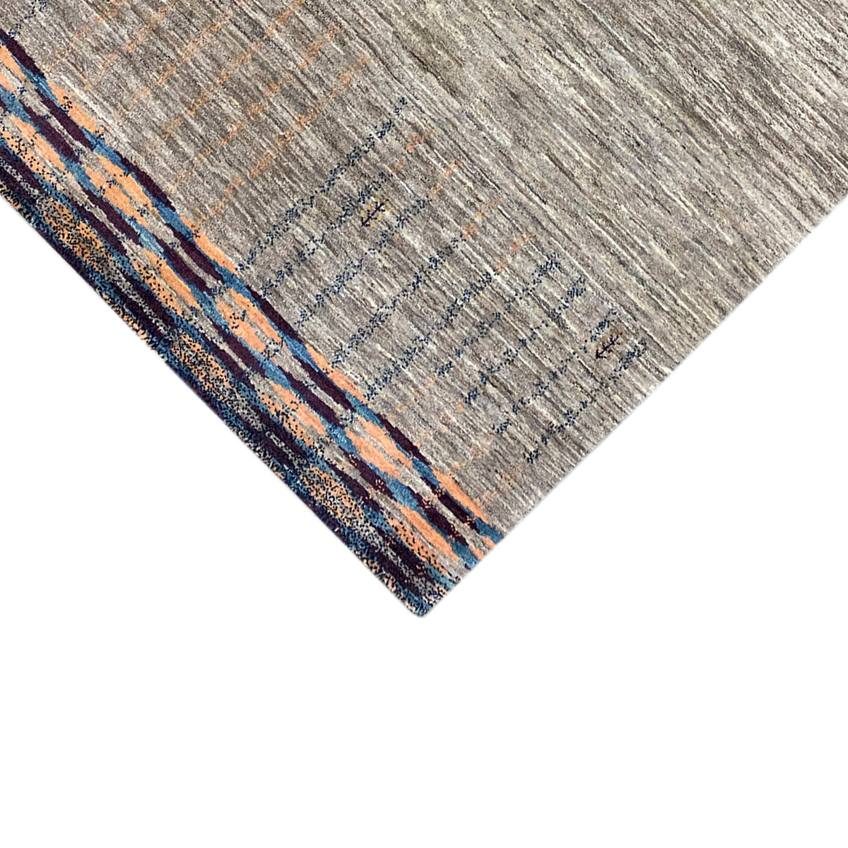 Corner view of Gabbeh rug: gray weave with a blue-orange border border