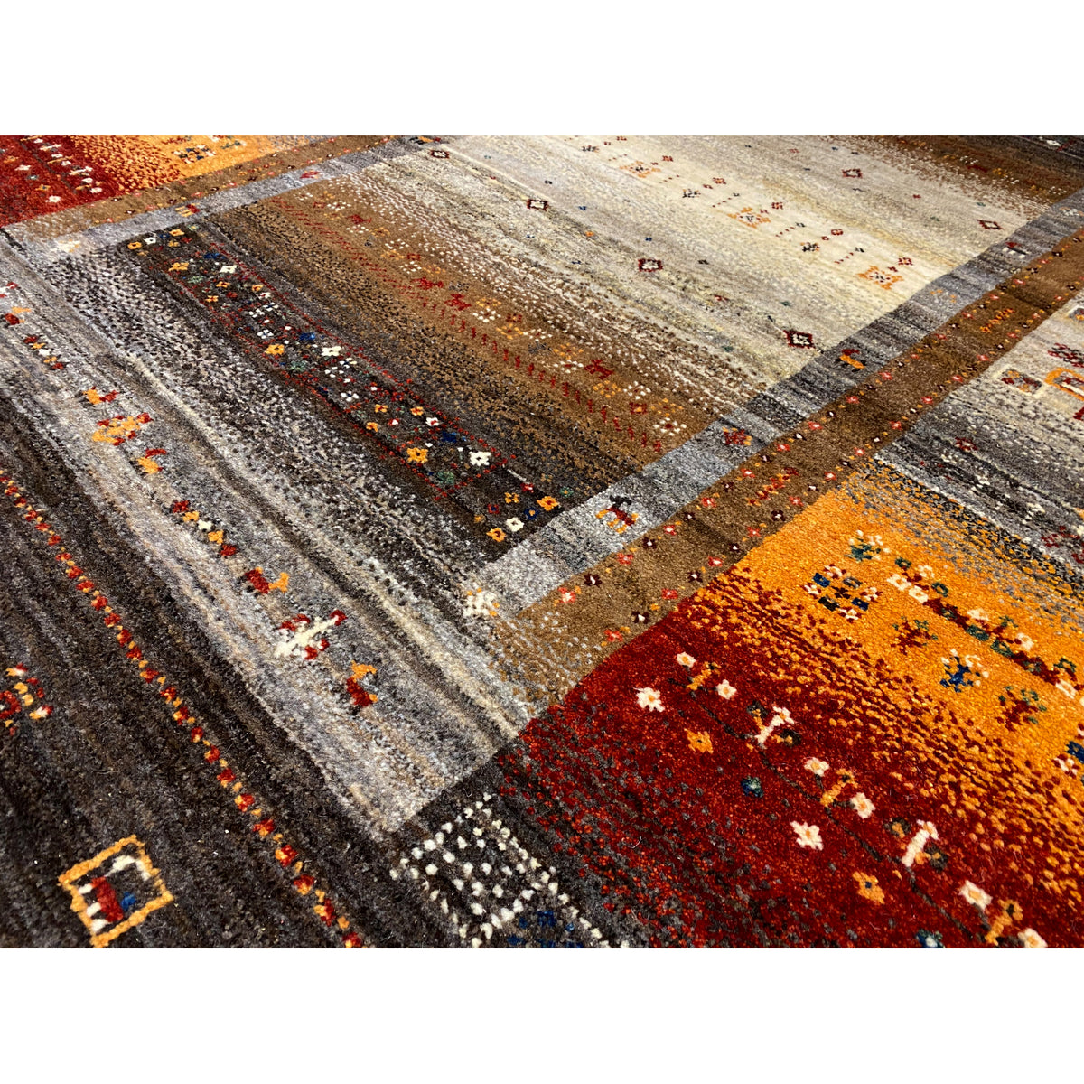 Close-up: multicolored patterns and lines on a brown-gray Gabbeh rug