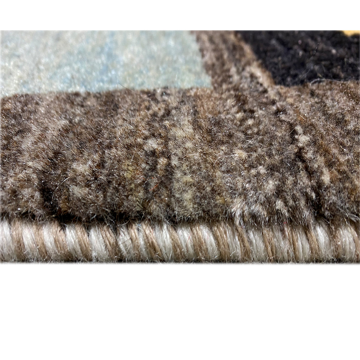Gabbeh rug pile detail at the edge, brown-beige and dark fibers