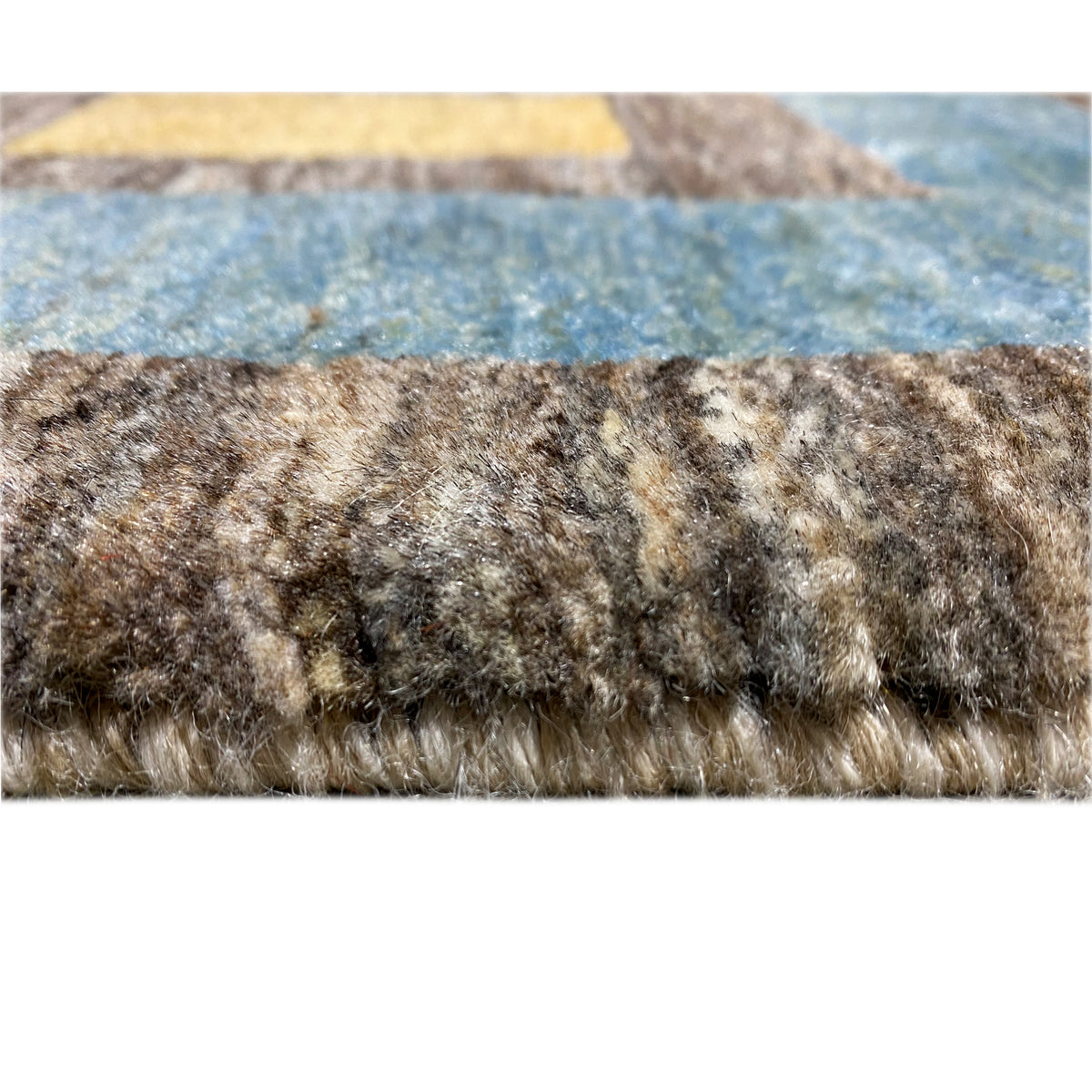 Gabbeh rug with short fringes along the edge, mottled in brown, gray, and blue