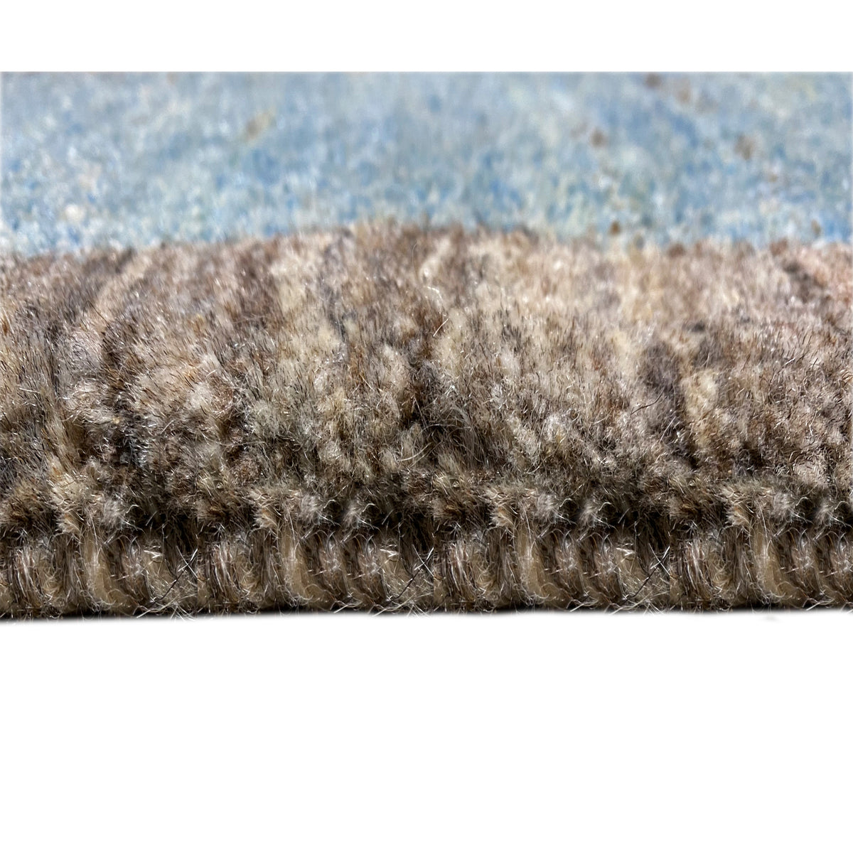 Carpet pile in detail: dense pile with multicolored fibers in blue, gray, and brown