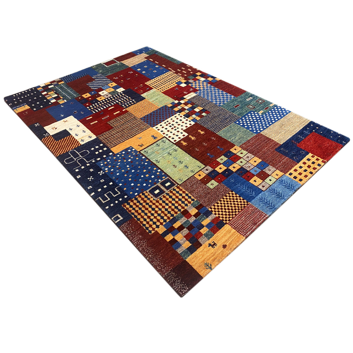 Gabbeh rug in a patchwork design, angled view: many pattern blocks in blue and red