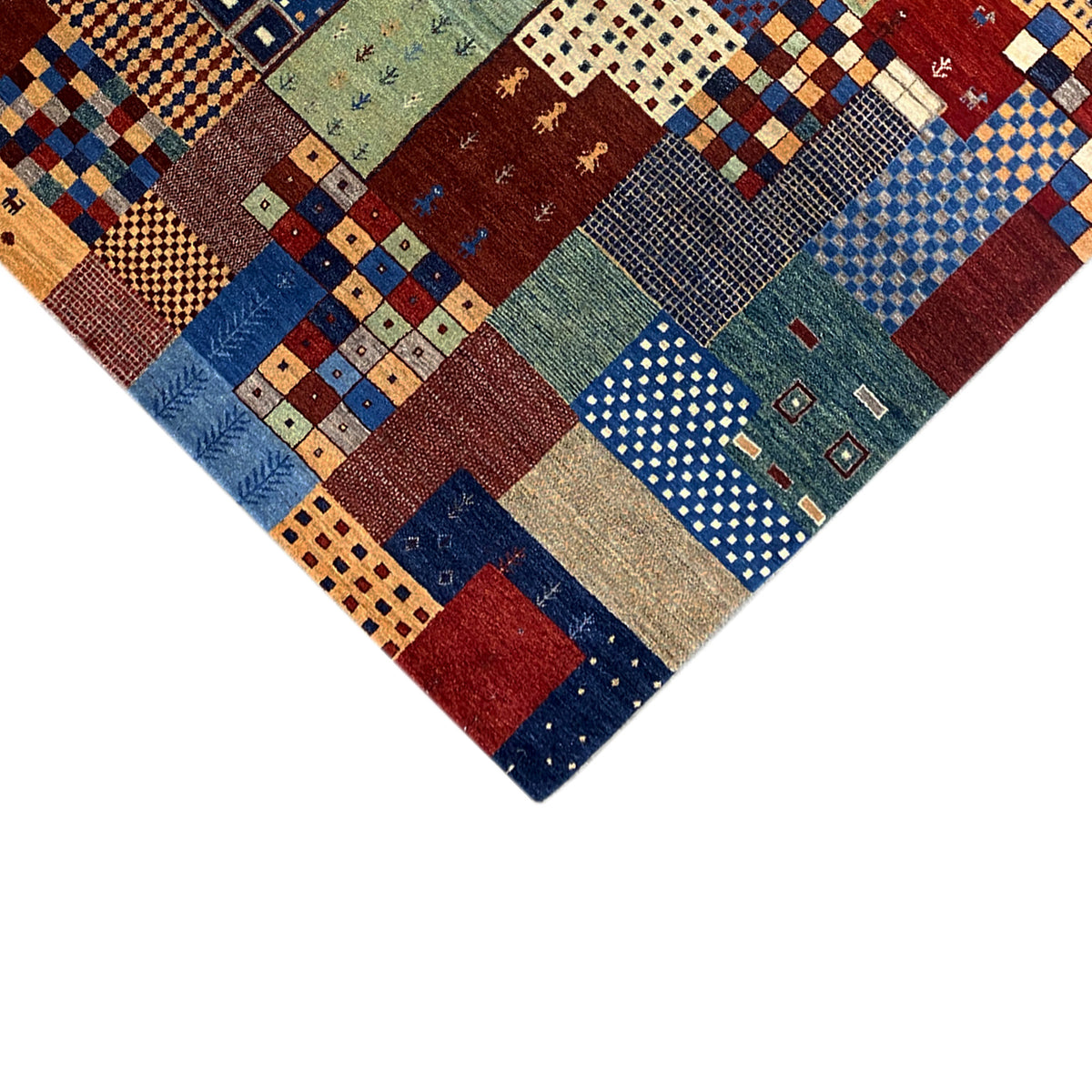 Gabbeh rug detail edge: patchwork motifs with colorful patterns and woven-in texture