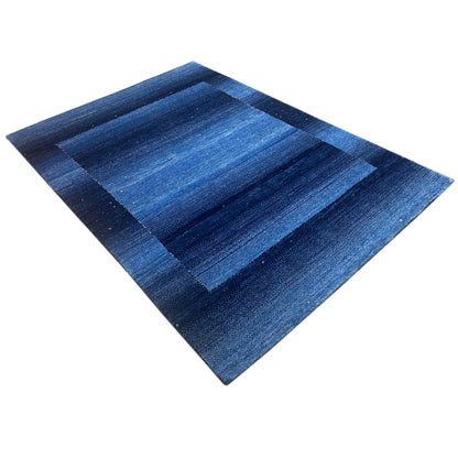 Gabbeh rug in blue with striped patches, laid diagonally, clearly visible woven texture