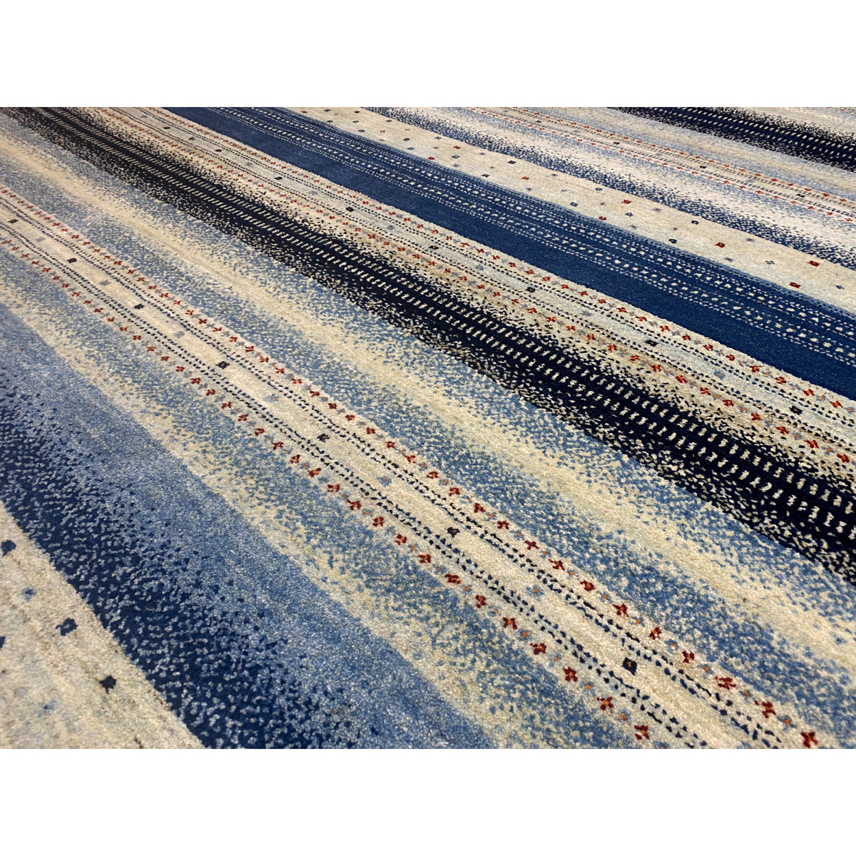 Detailed view of Gabbeh rug: fine striped pattern with small dots in blue and beige