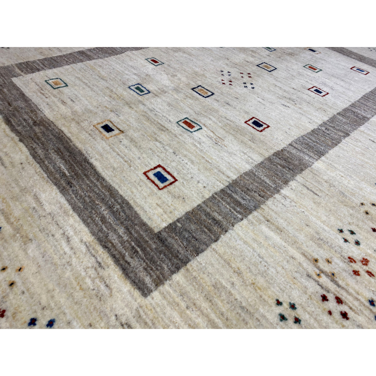 Detail view: beige carpet fabric with a gray border and colorful squares