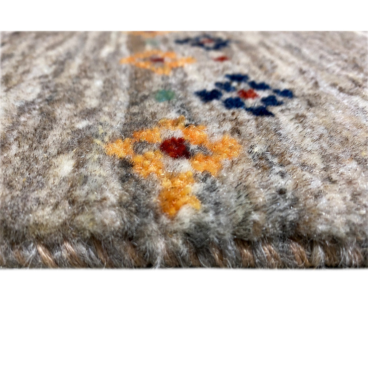 Close-up of a Gabbeh rug with colorful ornaments and a dense pile texture