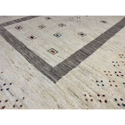 Close-up of a Gabbeh rug: central diamond field, gray border, beige background, and dot pattern