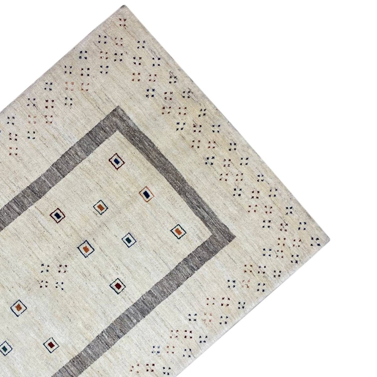 Gabbeh rug corner: beige border with dot and diamond patterns in the gray frame