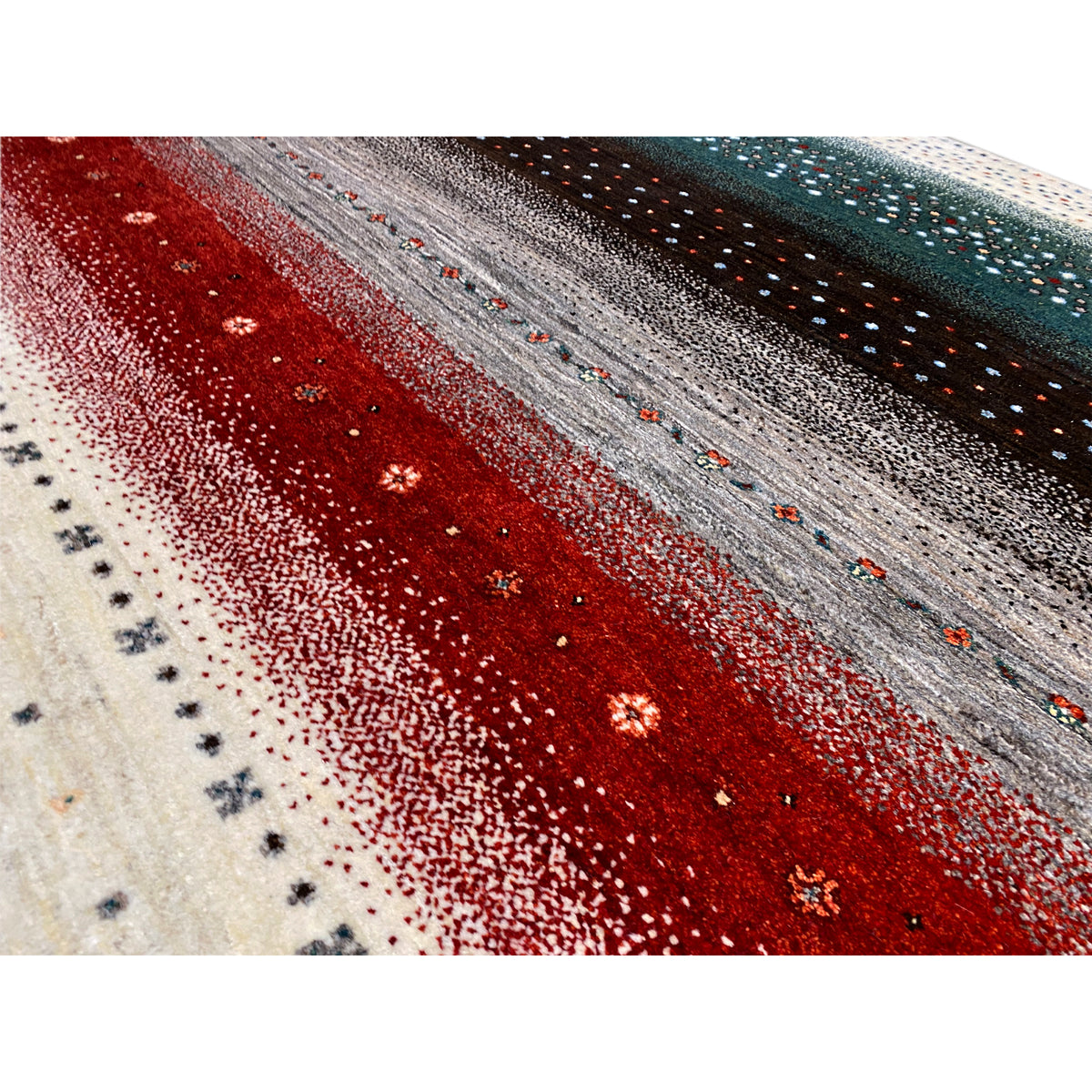 Close-up of a Gabbeh rug: red and gray stripes with dots and glossy effects.