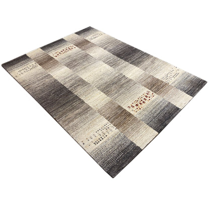 Gabbeh rug with a square patchwork pattern in gray, cream, and subtle red details