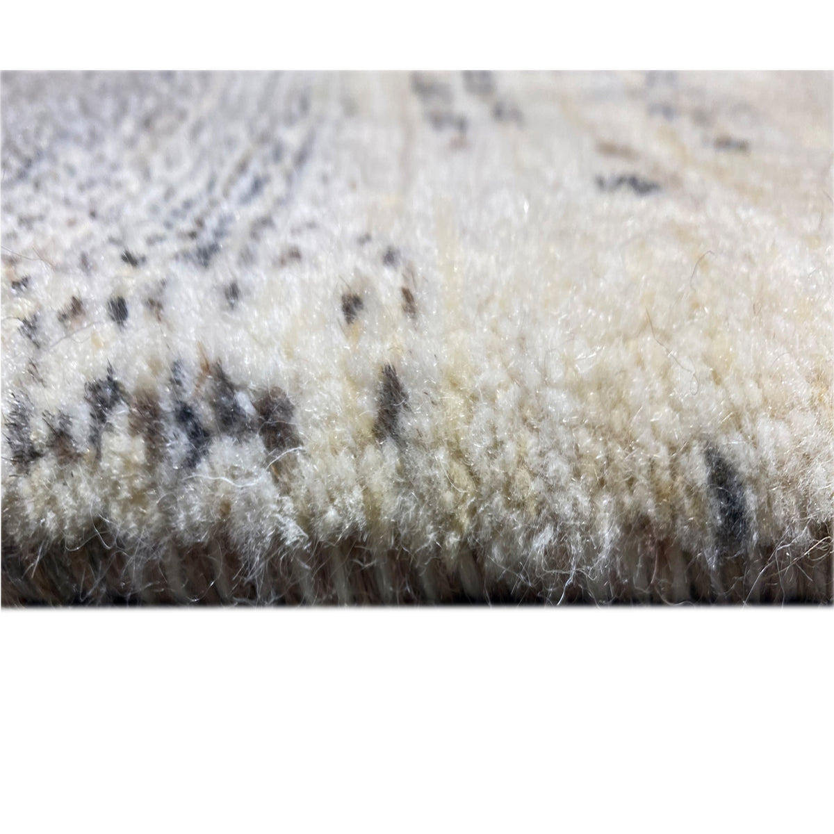 Gabbeh rug close-up of the pile surface in cream with dark gray sections
