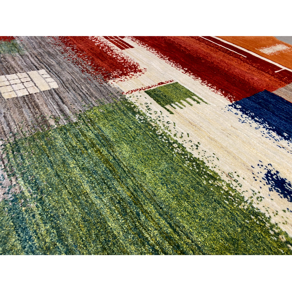 Gabbeh rug detail with geometric bars and dots in red, blue, green, and cream