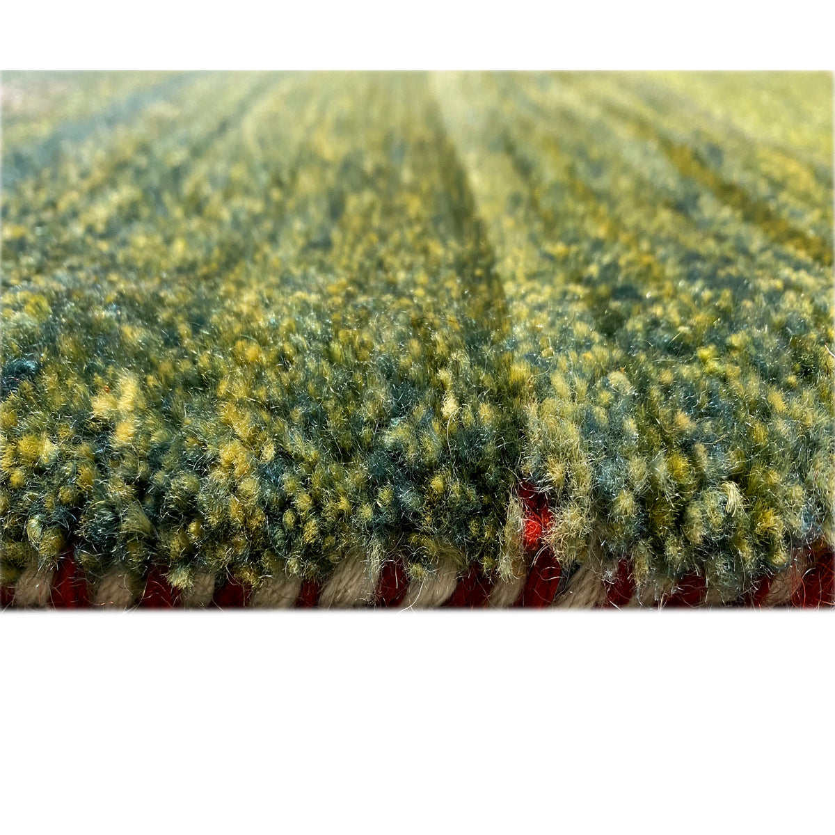Gabbeh rug with a dense pile, greenish-yellow texture, and delicate pattern impressions