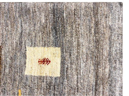 Gabbeh-Teppich Close-up: grauer Flor mit hellem Quadrat und kleinem roten Motiv
