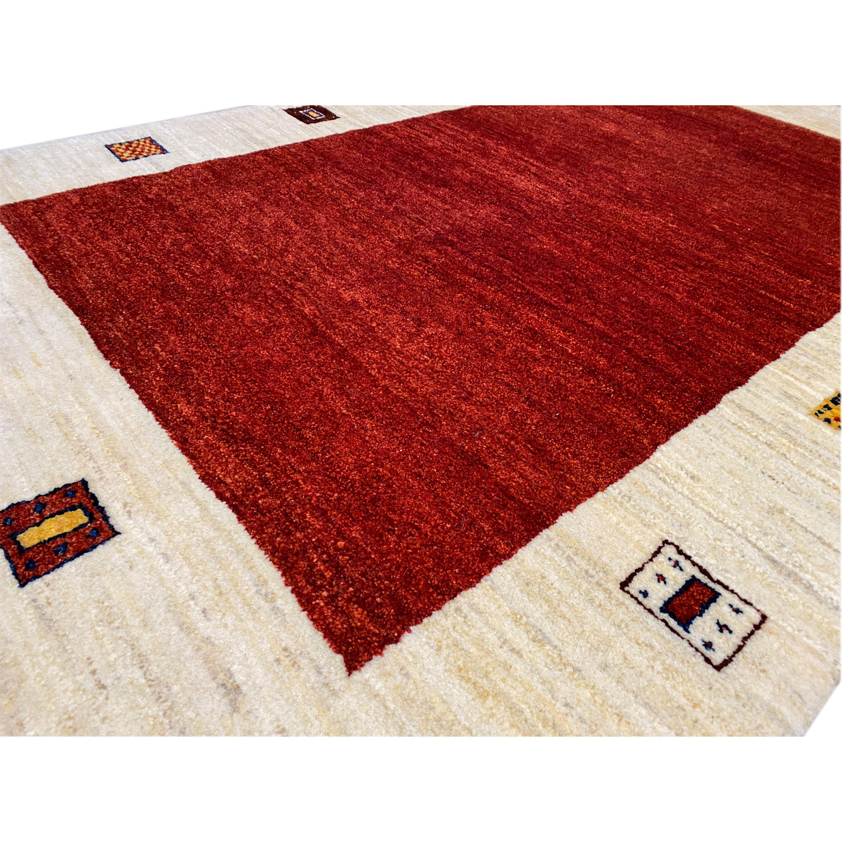 Rug detail: red geometric pattern with a beige border and woven-in squares