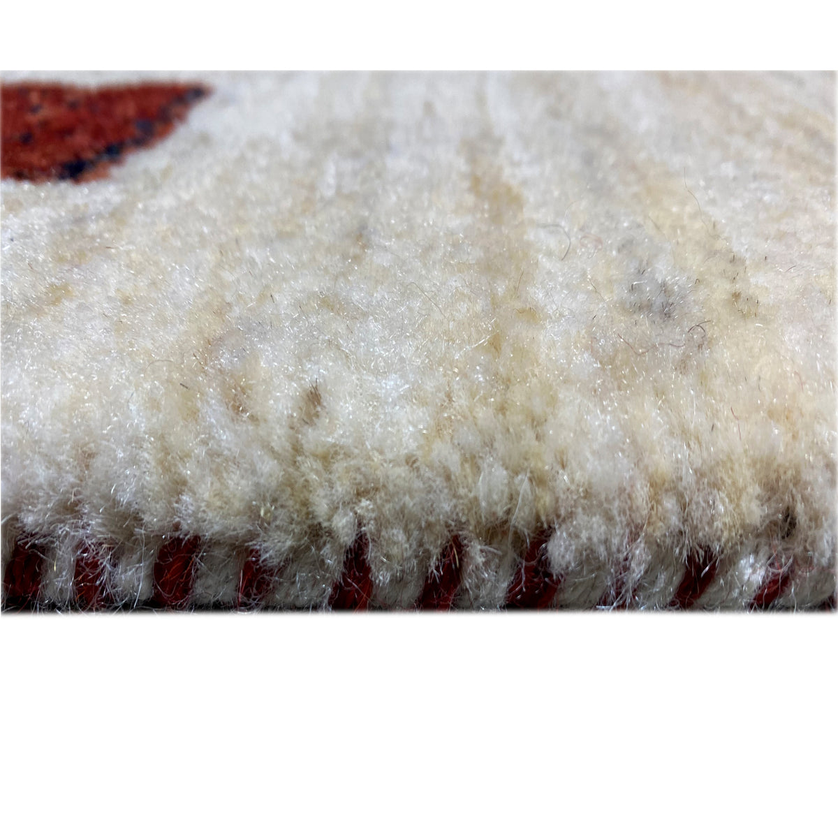 Carpet pile close-up: dense light beige pile with a dark lower edge