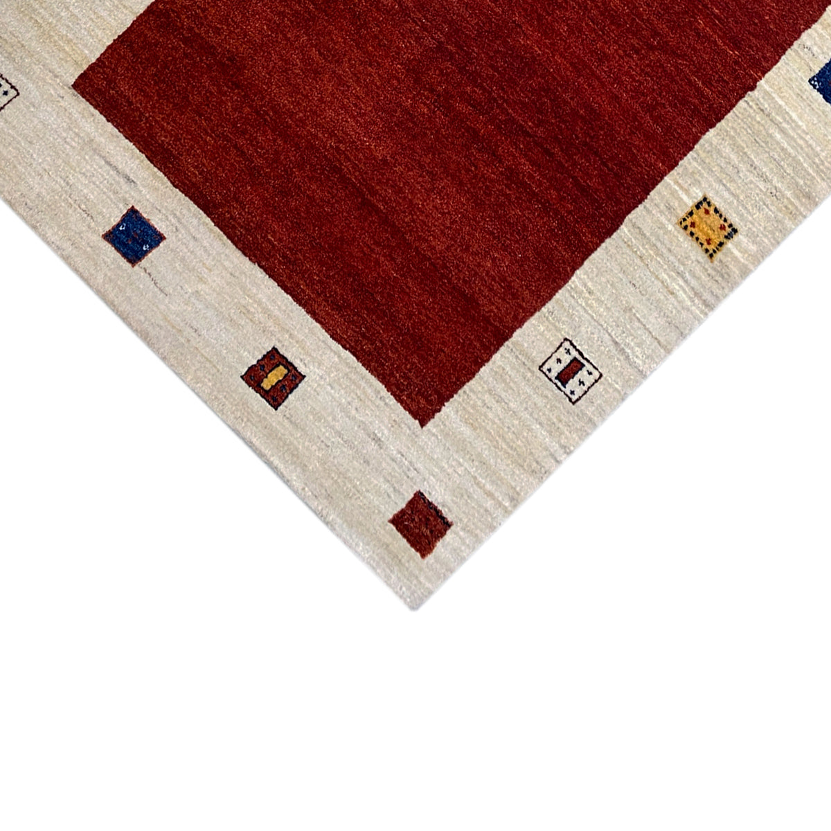 Carpet corner detail: red field, beige border, and small colorful square ornaments