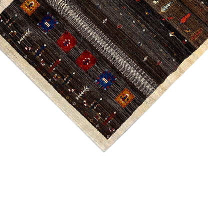 Close-up of the rug: beige border band and colorful square patterns on a dark background.