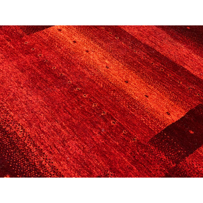Gabbeh rug detail, red-orange surface with an even texture