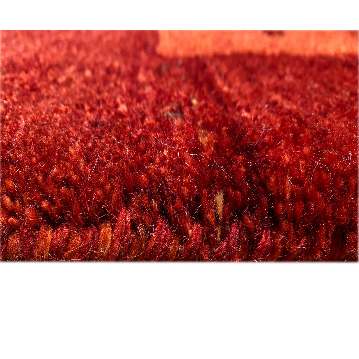 Gabbeh rug pile detail, dense red wool rug with a bold texture