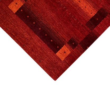 Gabbeh rug detail, red with square patterns and a fine woven texture