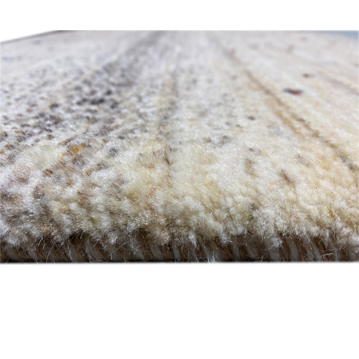 Gabbeh rug detail of the pile surface, beige-gray with a subtle textured pattern