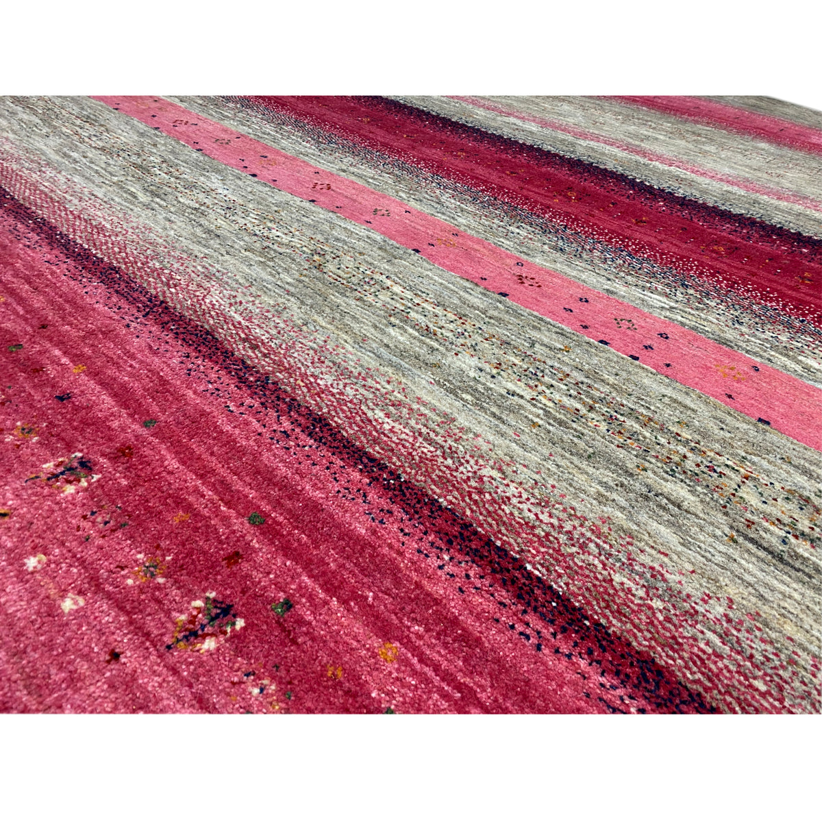Close-up of a Gabbeh rug: pink stripes on a gray background, fine texture