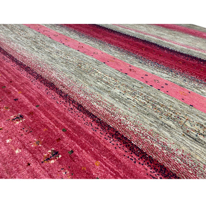 Close-up of a Gabbeh rug: pink stripes on a gray background, fine texture