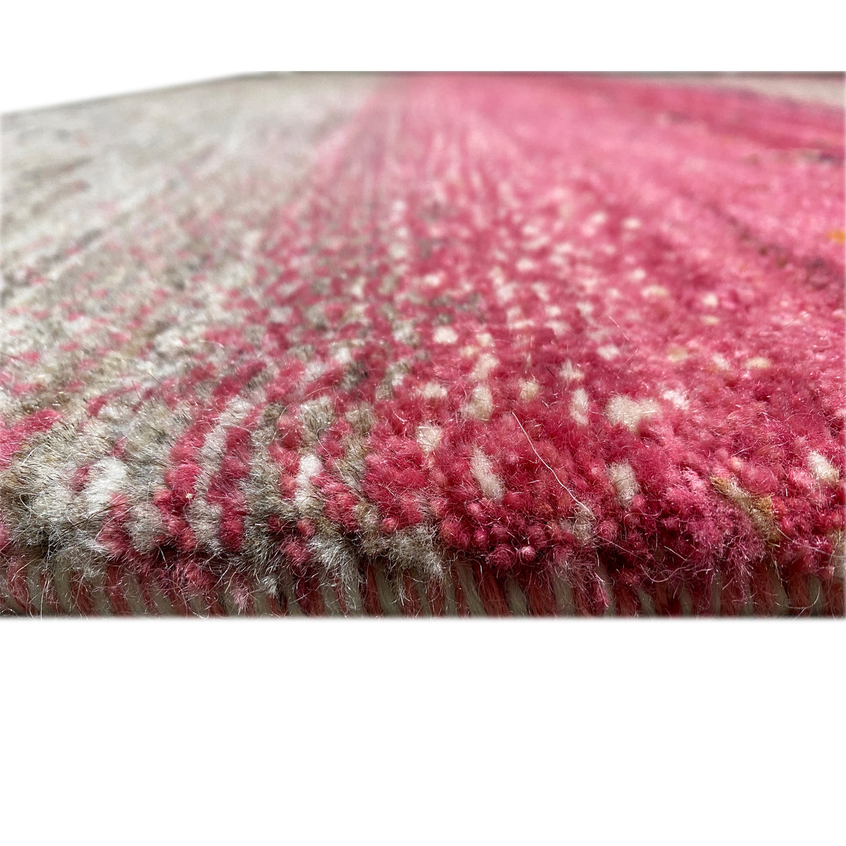 Gabbeh rug detail: pile and edges, pink and gray in a striped pattern