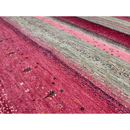 Close-up of the Gabbeh rug: mottled texture, fine dots in the pink-gray pattern
