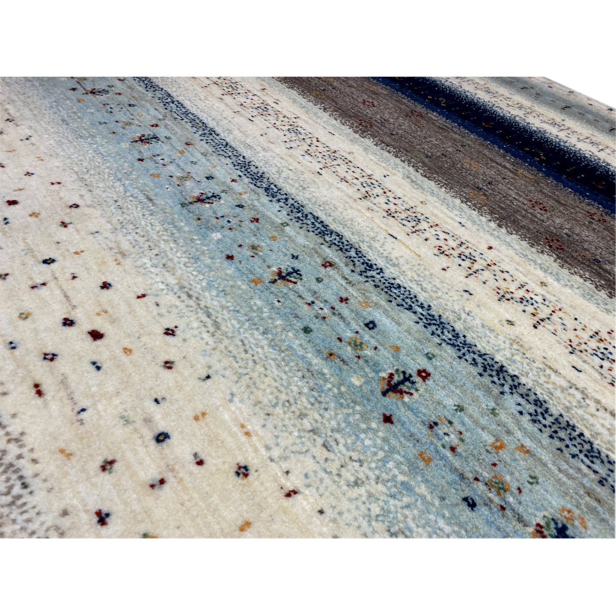 Gabbeh rug detail: light dots and multicolored ornaments in shades of blue and gray