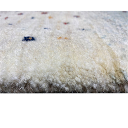 Gabbeh rug pile in close-up, soft light surface with dark color specks